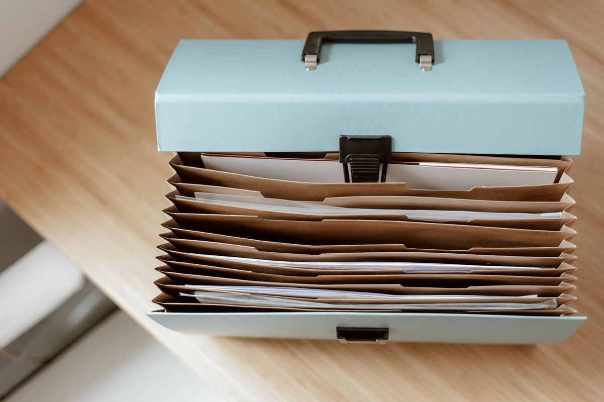 Accordion file box of sorted documents standing open on a desk