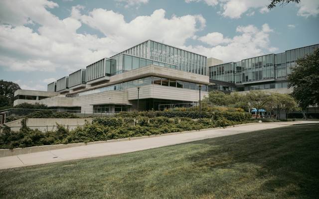 Glass and concrete institutional buildings above a landscaped lawn