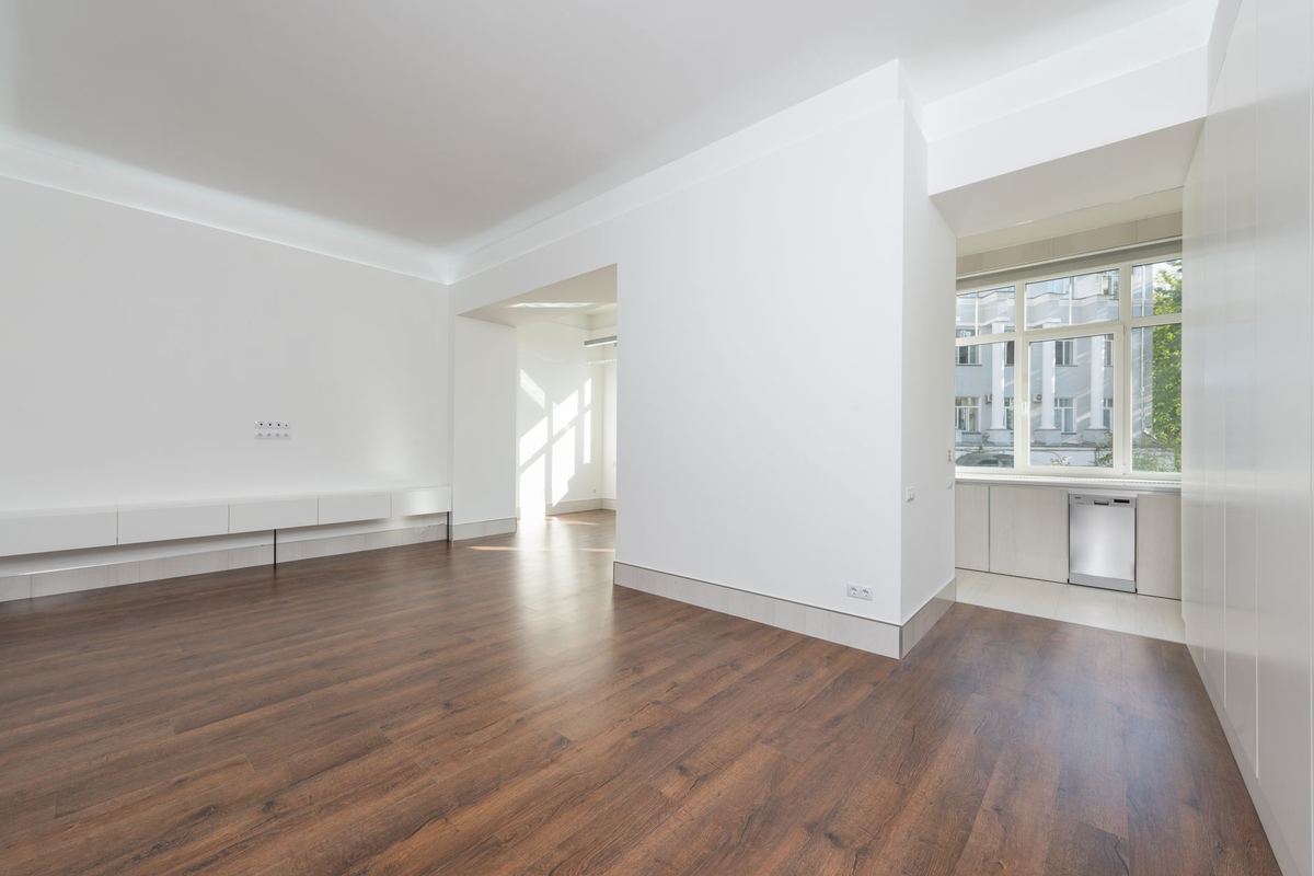 Empty apartment rooms with wood floors and daylight from two sides