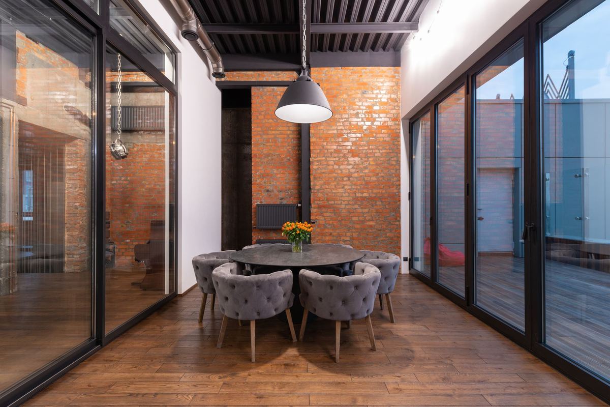 Converted loft interior with exposed brick, timber floors and a round dining table