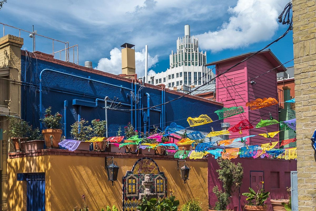 Papel picado banners over a painted courtyard in the San Antonio market district