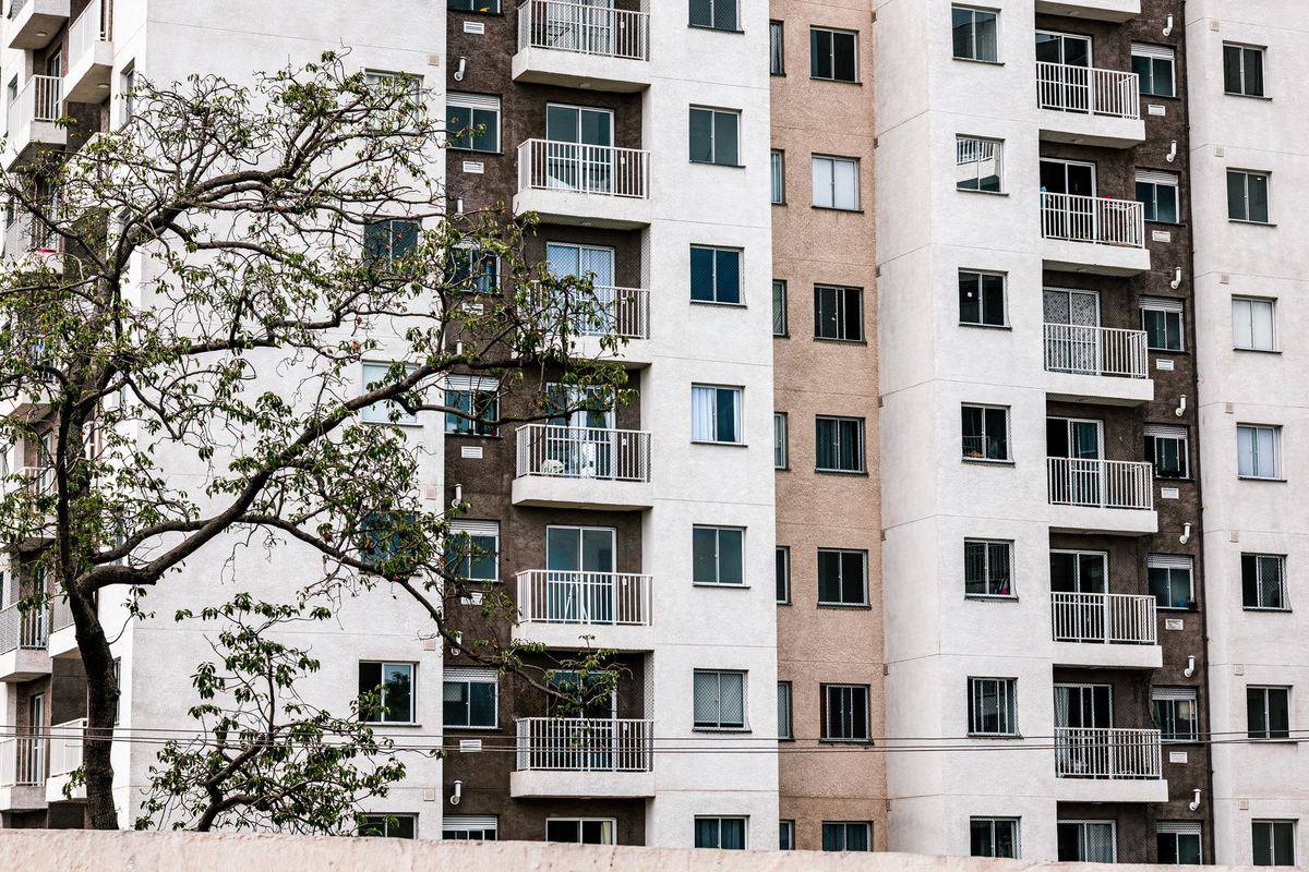 Older mid-rise apartment building with rows of small balconies