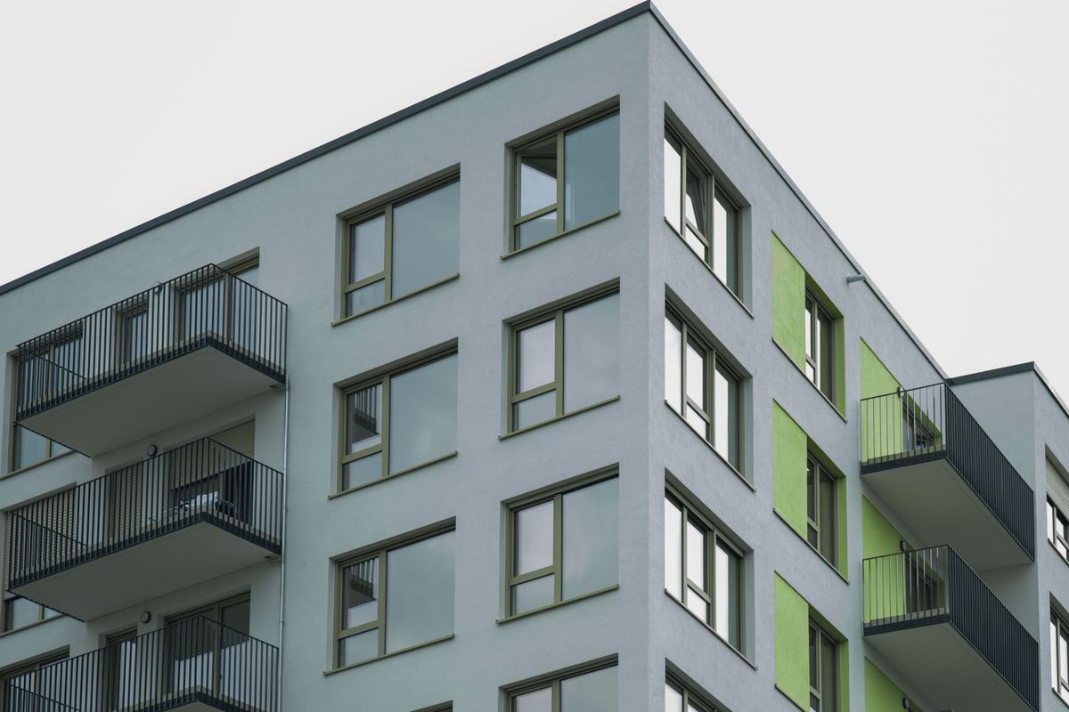 New apartment building corner with recessed balconies against a clear sky