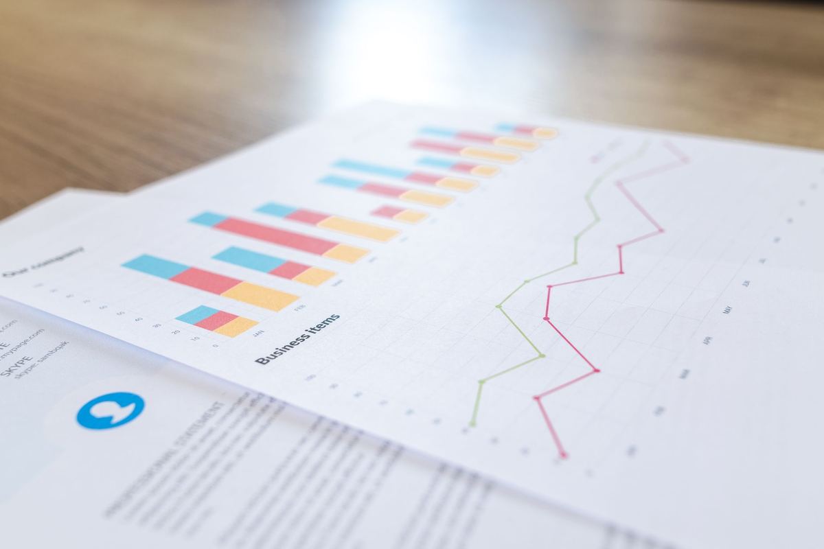 Printed bar and line charts on a sheet of paper on a wooden table