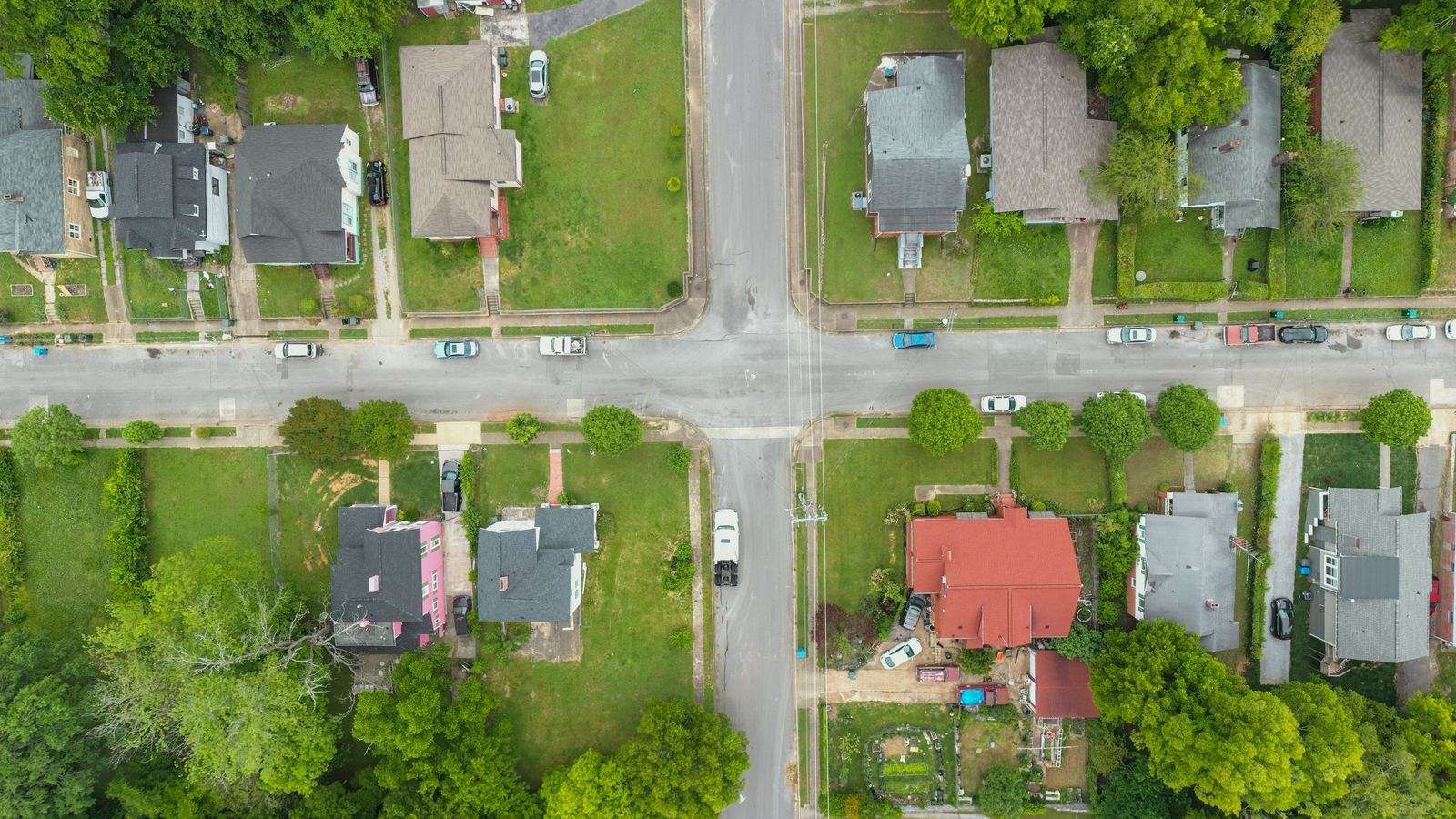 Aerial view of a tree-lined street of single-family homes and yards
